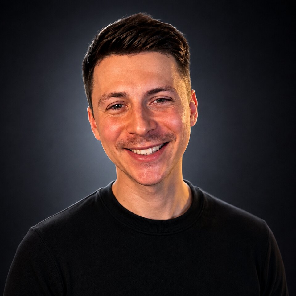 Agrici Daniel smiling in a studio portrait